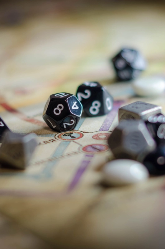 En håndfuld polyheldrale terninger ligger på et fantasy lande-kort.